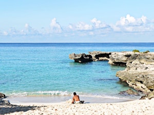 Boy sitting at beach in Smith Cove in the Cayman Islands