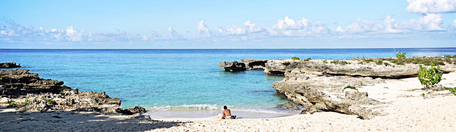 Boy sitting at beach in Smith Cove in the Cayman Islands