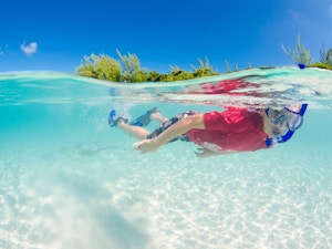 Boy snorkeling in clear water in the Cayman Islands