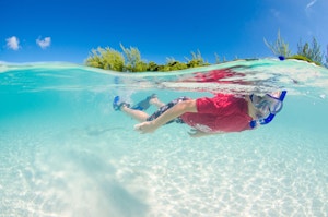 Boy snorkeling in clear water in the Cayman Islands