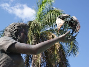 Female statue holding a metal earth at Heroes Square in the Cayman Islands