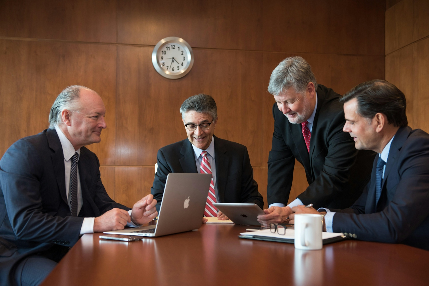 Four white businessmen sitting around a boardroom table