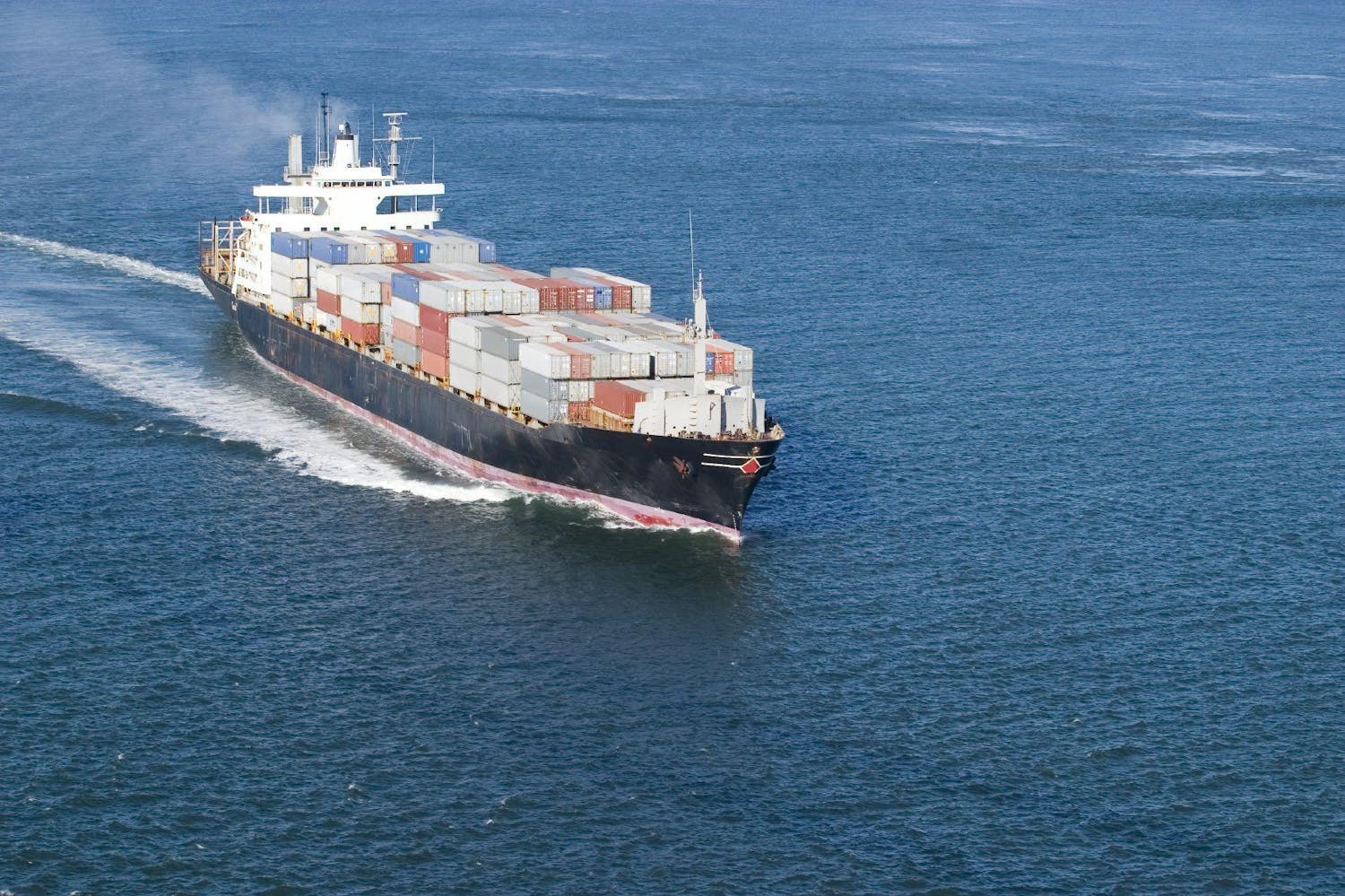 Full container ship transporting cargo in the ocean