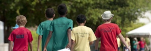 Group of young boys walking next to an athletics track