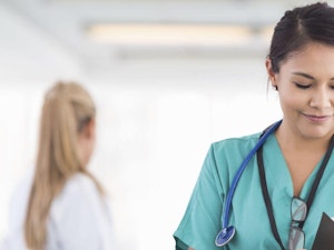 Health Care Professional reviewing chart in hospital hallway