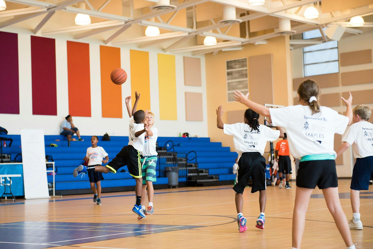 Kids playing basketball at an indoor sports facility