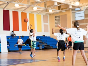 Kids playing basketball at an indoor sports facility