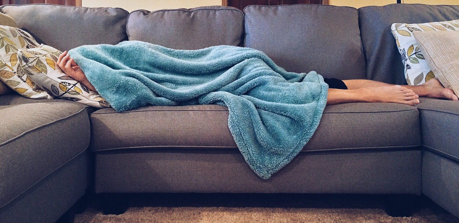 Lady on couch under blanket sick with Dengue