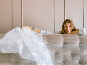Lady unwrapping plastic off couch after moving