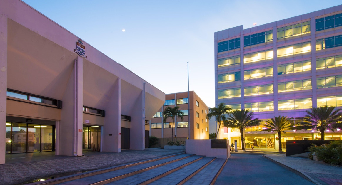 https://acorn-media.imgix.net/images/Office-buildings-in-Cayman-during-a-sunset.jpg?auto=format&crop=focalpoint&domain=acorn-media.imgix.net&fit=crop&fp-x=0.5&fp-y=0.5&h=630&ixlib=php-3.3.1&q=82&w=1200