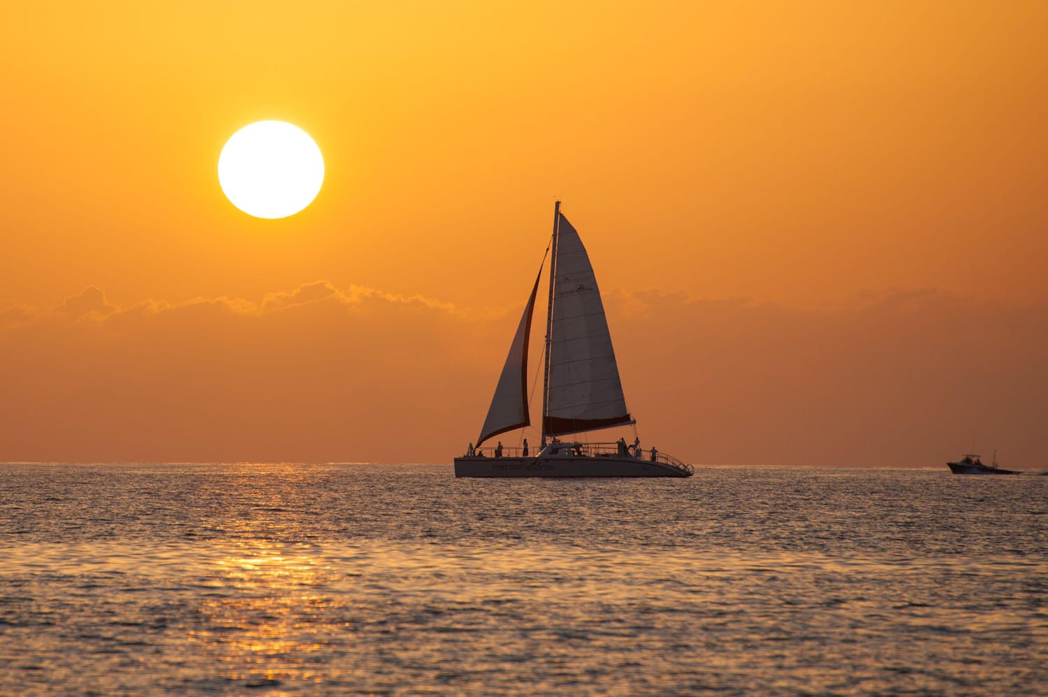 Sailing boat on out at sea during sunset