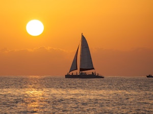 Sailing boat on out at sea during sunset