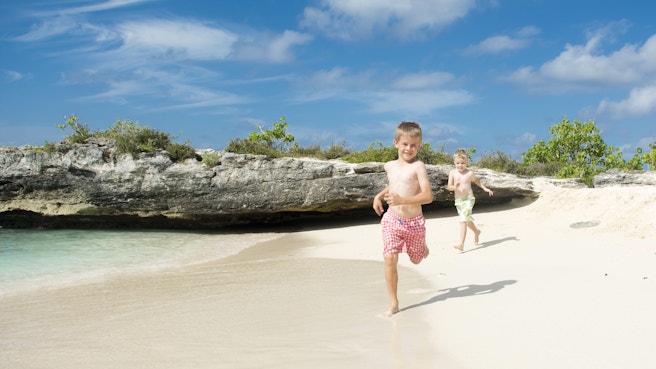 Two little boys running down the beach at Smith Cove
