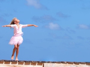 Young ballerina practicing on a wooden pier