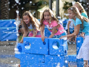 Young girls playing near a water fountain