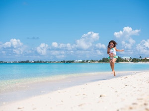 Young girls wearing sunglasses running on the beach