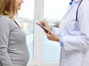 Close crop of pregnant woman getting health exam by doctor