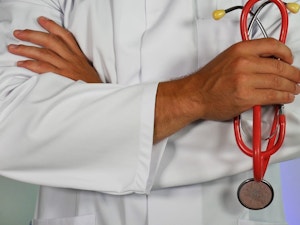 Doctor in white coat holding stethescope close up