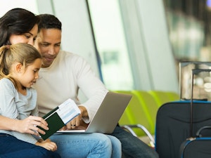 Family sitting in airport with luggage