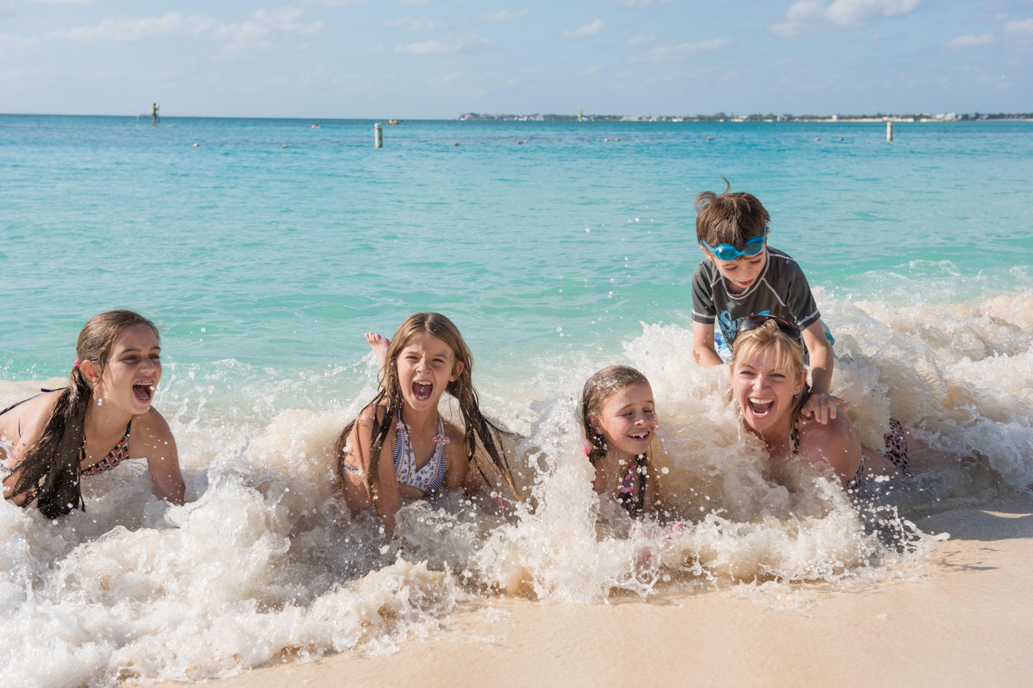 Four young kids playing in the surf