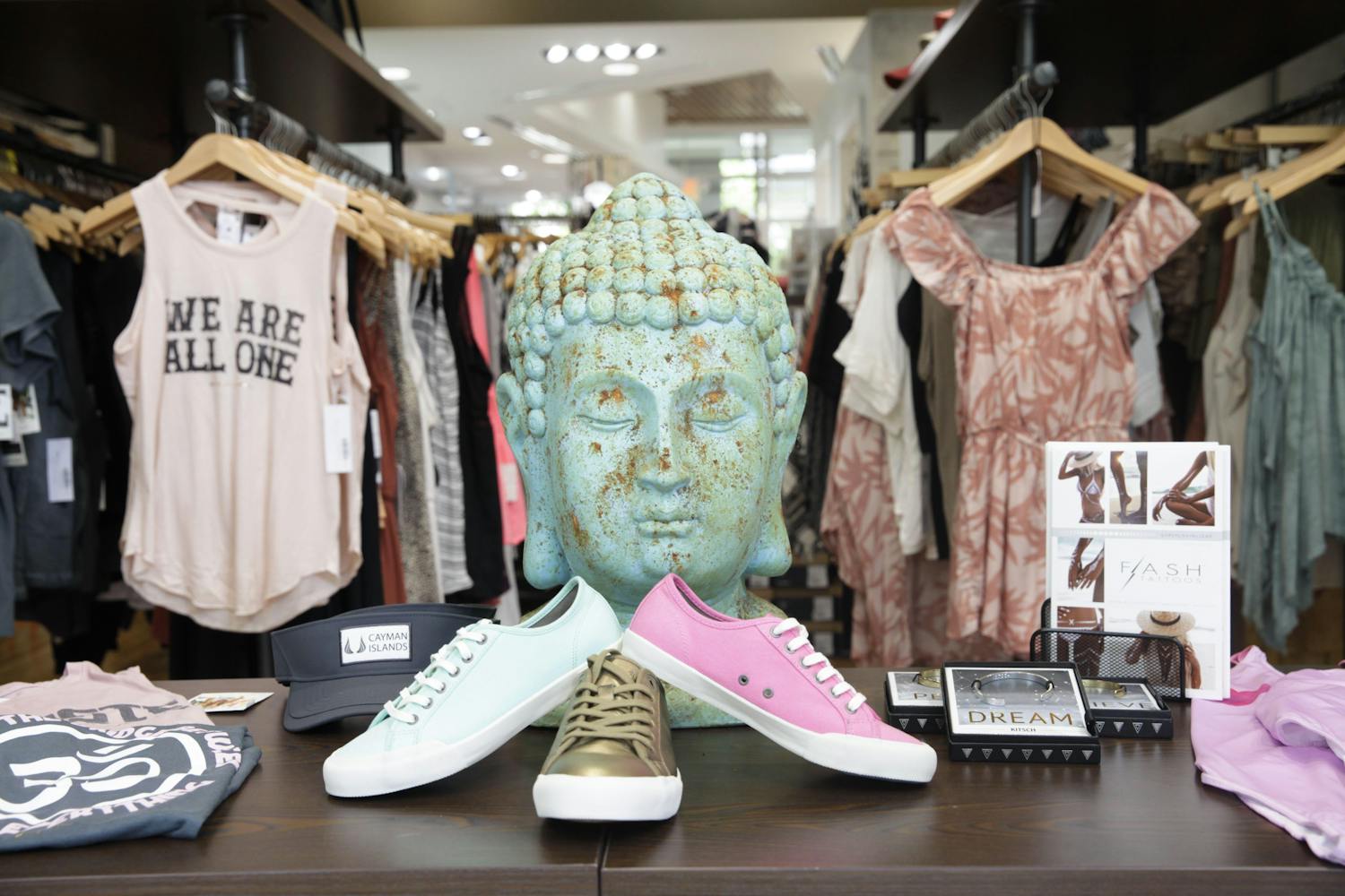 Front window display of shoes and tanks with an ornamental buddah head in the centre