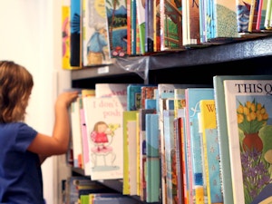 Little girl looking for books in bookstore