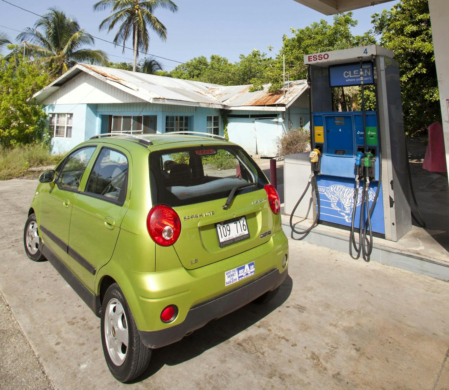 Little green car parked out from of an esso