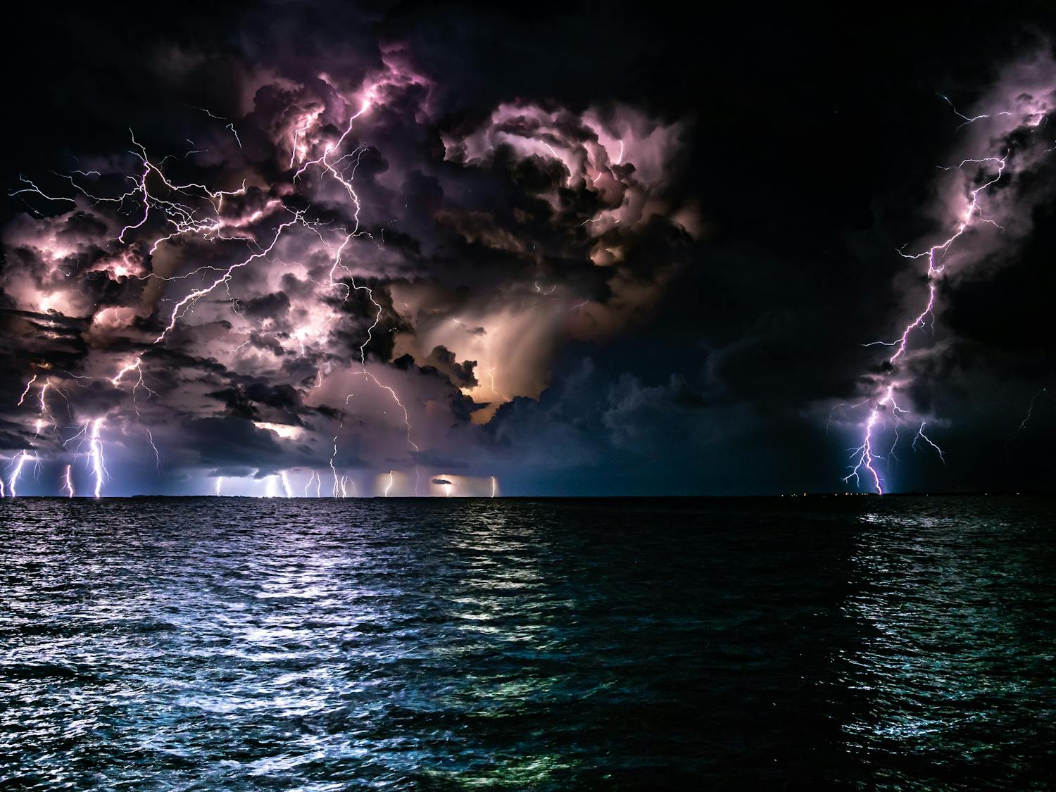 Many lightening strikes in a stormy sky overlooking the ocean