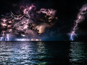 Many lightening strikes in a stormy sky overlooking the ocean