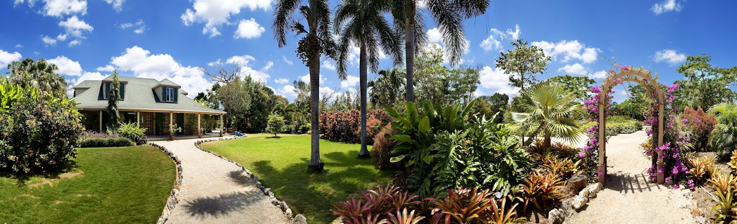 Panoramic view of a beautiful house with front yard garden and arch