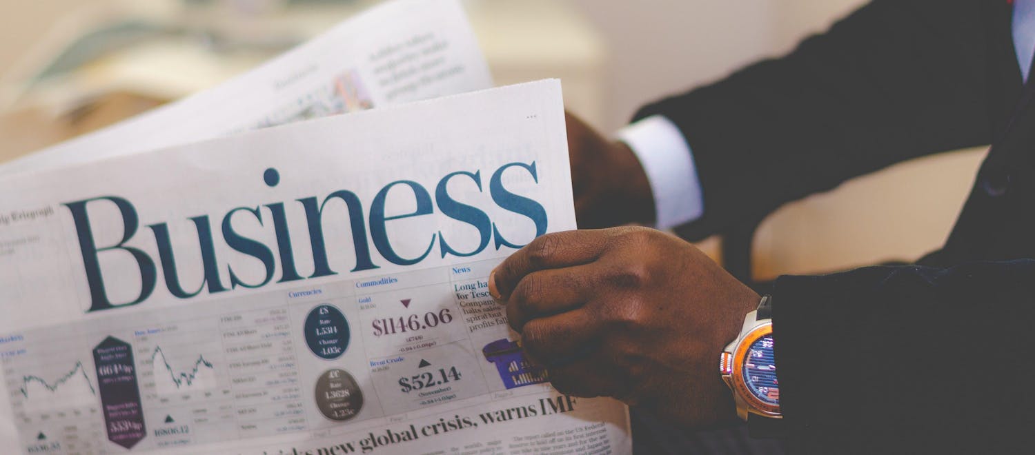 Person reading the business section of the newspaper