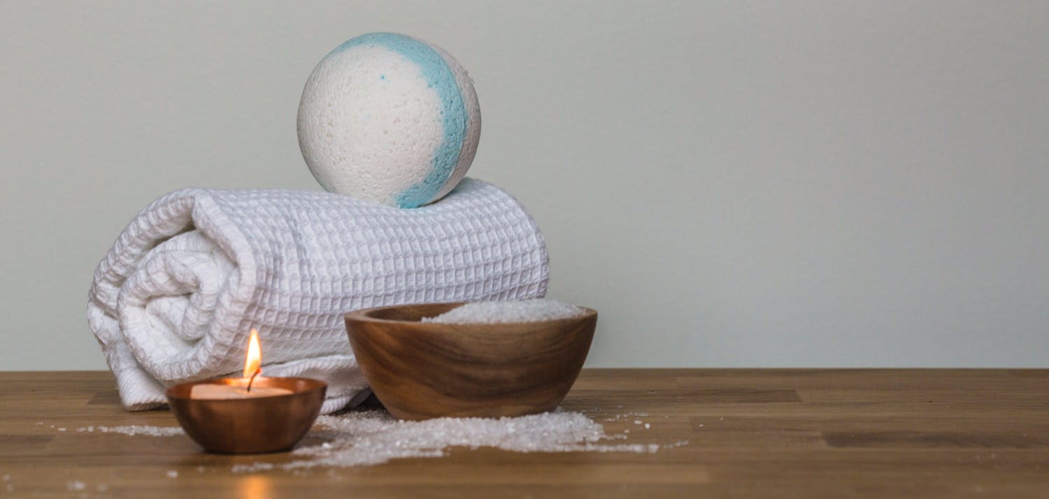 Photo of towel and bath bomb near candle