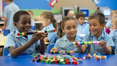 Three school age children playing with blocks